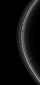 Prometheus (86 km de diamètre) continuant son orbite après avoir perturbé l'anneau F